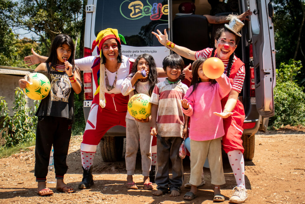 As palhaças Trancinha e Frufru distribuem brinquedos e doces para as crianças da Aldeia.